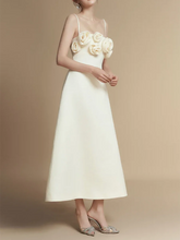 White dress with floral embellishments on a beige background